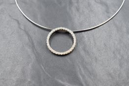 An 18ct white gold diamond set circular pendant, the open pendant set with thirty-four round