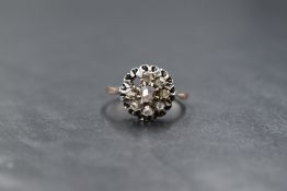 A yellow metal presumed gold diamond set cluster ring, the central mixed cut diamond measuring