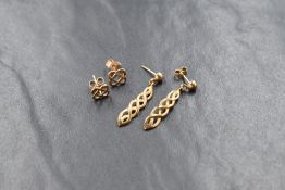 A pair of yellow metal Celtic knot stud earrings, along with a pair of yellow metal infinity knot