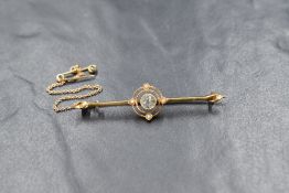 An Edwardian 15ct gold bar brooch having a central white stone (not a diamond) within an open