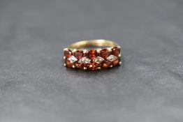 A 9ct gold fire opal ring having two rows of five fire opals with two central diamond chips in