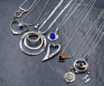 A group of ten silver necklaces, including lapis lazuli set pendants, a tribal garnet set pendant