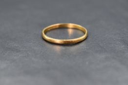 A 22ct gold band, of thin plain rounded form, marked 22 with hallmarks, ring size W, 2.2g