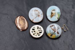 A group of four 9ct gold mounted kookaburra motif brooches, three of painted pottery and one of