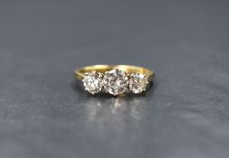 An 18ct gold three stone diamond ring, the central brilliant cut diamond being approx 1.25ct flanked