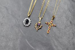 A 9ct gold sapphire and cubic zirconia set cluster pendant, the central oval cut sapphire in a cubiz