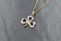 A 9ct gold sapphire and cubic zirconia set clover pendant, the three leaf clover motif pendant
