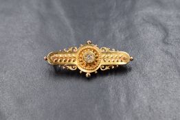 An 18ct gold diamond set bar brooch, the central old cut diamond within a decorative twisted rope