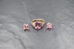 A 9ct gold pink sapphire ring having an emerald cut sapphire in a four claw set mount with diamond