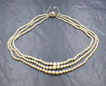 A triple string of graduated cultured pearls with 9ct gold circular box clasp having pearl and