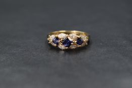 A 14ct gold ring by QVC having blue & white paste stones in a decorative band setting on a 14ct gold