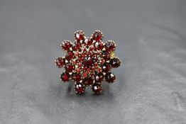 A 9ct gold Bohemian garnet set floral cluster ring, the central rose cut garnet in a four tier