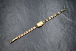 A lady's 9ct gold Rotary quartz wrist watch having a baton numeral dial on a rectangular face in a