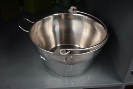 A modern stainless steel dairy pale, with shallow spout, rear handle and swing over-handle