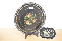 A 20th-century toleware decorative plate, featuring a hand-painted floral design and repeating