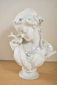 A Victorian Parian ware bust of a young woman with a bird on her right shoulder, wearing a floral