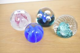 A selection of four Caithness Scotland studio art glass paperweights, featuring '