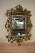 A 20th-century brass Baroque-style decorative wall mirror, featuring intricate foliage detailing,