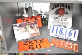 A mixed lot of vintage license plates, including an American Ohio 1922 plate and a New Brunswick,