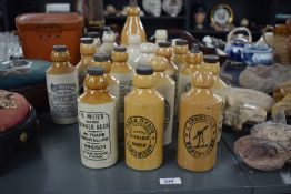 A collection of nineteen antique stoneware ginger beer bottles, twelve with original rubber tops, to