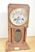 A 1930s/1940s oak mantel clock with circular dial having Arabic hours, two winding holes over a