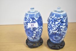 A pair of Chinese porcelain 'spirit' bottles, each of cylindrical form with a tapered, rounded
