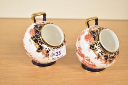 A pair of Royal Crown Derby 'Imari' pattern condiment pots of circular form raised on a footed base,