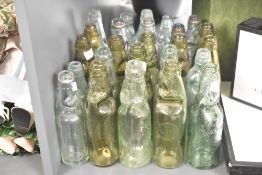A collection of 25 early 20th-century green glass Codd-neck bottles, featuring examples such as '