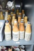 A collection of twenty three stone ware ginger beer and similar bottles, various to include John