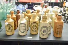 A collection of seventeen 20th-century stoneware ginger beer bottles from various makers and