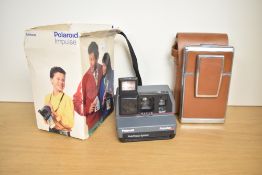 Two late 20th-century Polaroid film cameras, featuring a Polaroid SX-70 Land Camera with original
