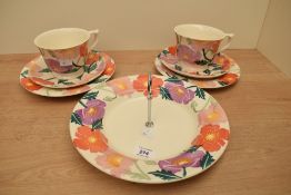 Two Emma Bridgewater pottery Bright Poppies pattern breakfast trios and a single tier cake plate