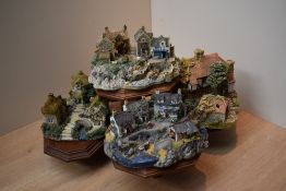A group of four Liliput lane models on presentation stand to include 'Low Tide at Anchor Bay' and '