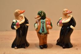 A group of three novelty duck and mallard figures comprising a mallard in a suit and two ducks in