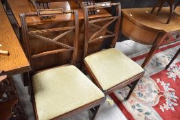 A pair of 19th Century Regency style dining chairs having overstuffed drop in seats