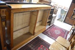 A late 19th or early 20th Century birds eye maple open bookshelf having ebonised ledge back, width