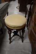 A Victorian mahogany adjustable piano stool having later upholstery