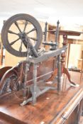 A traditional spinning wheel , dark stained