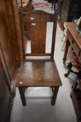 A Lakeland Arts & Crafts golden oak solid seat chair , having carved cruciform to back rail, stamped