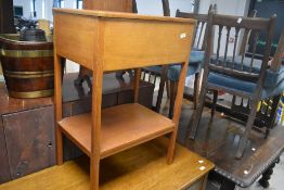 A traditional stained frame sewing table having lift lid with compartmental interior and undershelf,