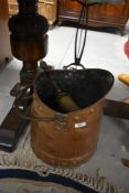 An Antique copper coal helmet, includes none matching brass shovel and coal