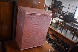 A woven fibre linen basket in pink sold together with a similar chair.