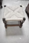 A traditional strung stool on stained frame