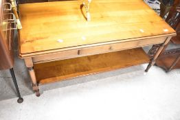 A reproduction yew effect coffee table having frieze drawer and shelved undertier