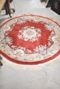 A circular Chinese rug, having red ground, with foliate decoration, diameter approx. 170cm,