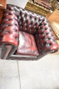 A Chesterfield style armchair in oxblood leather