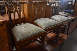 A set of three early to mid 20th Century dining chairs having drop in overstuffed seats