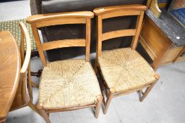 A pair of traditional rush seated chapel style rail back chairs