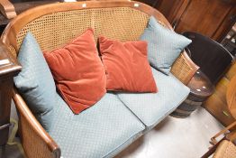 A Wesley Barrell two seater settee having canework back