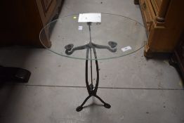 A modern wrought iron framed occasional table having oval glass top, approx. 45 x 30cm